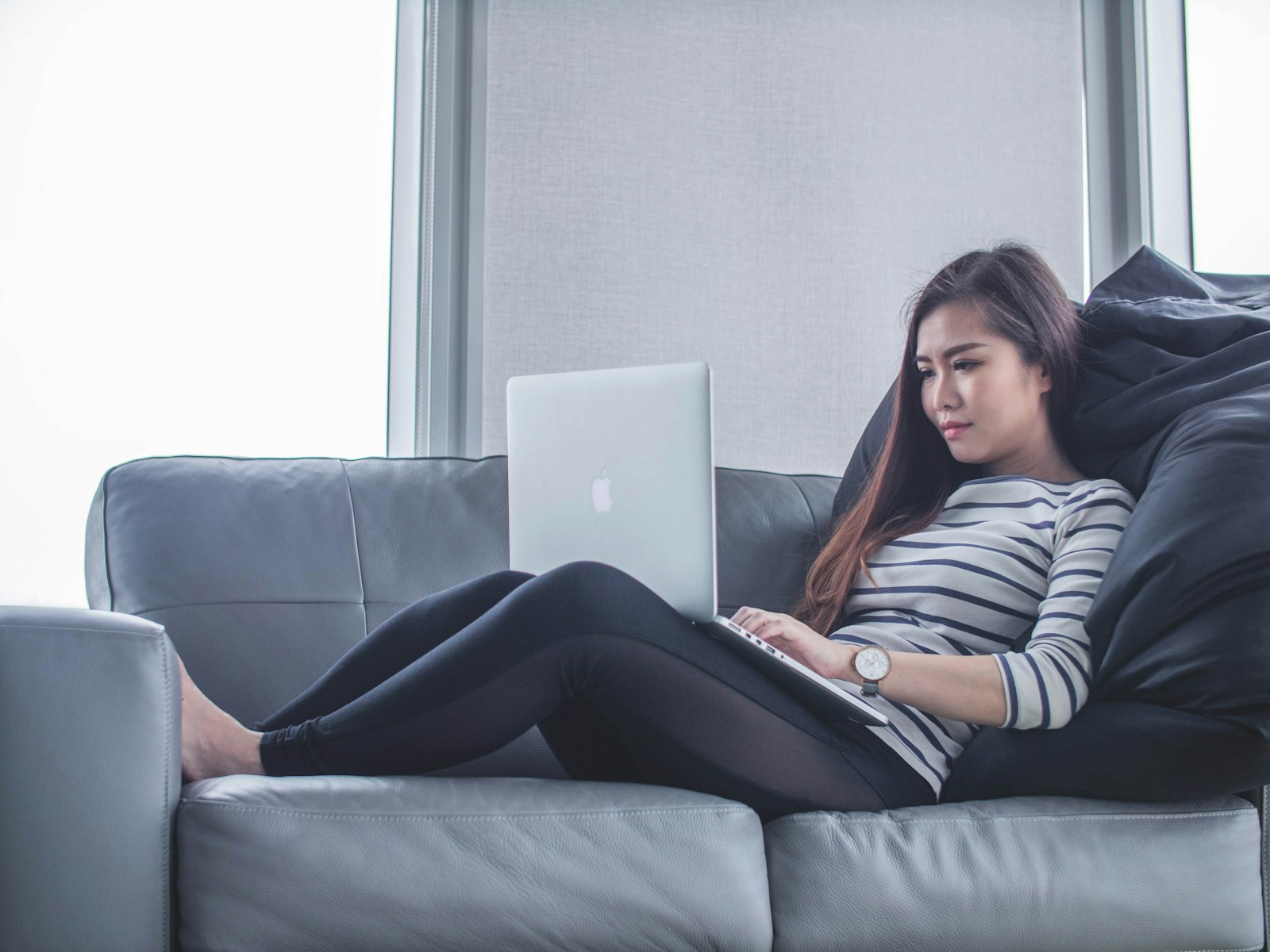 woman sitting on sofa while getting passive income