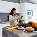 woman smiling while cooking vegetables