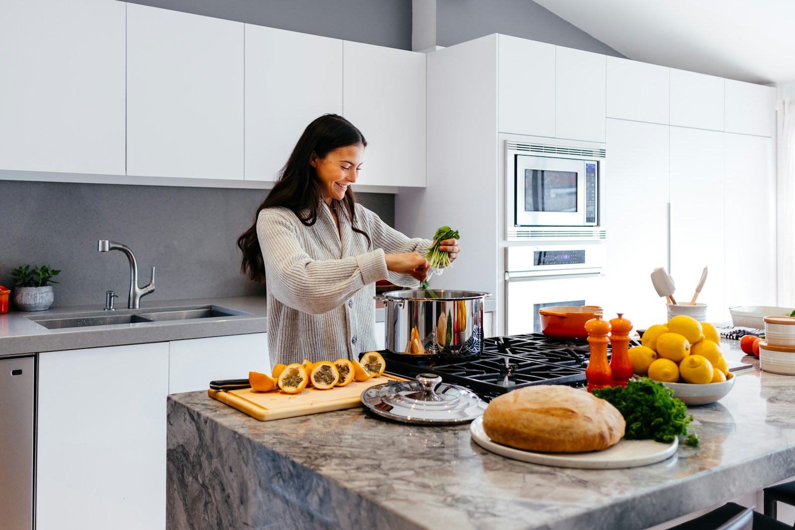 woman smiling while cooking vegetables